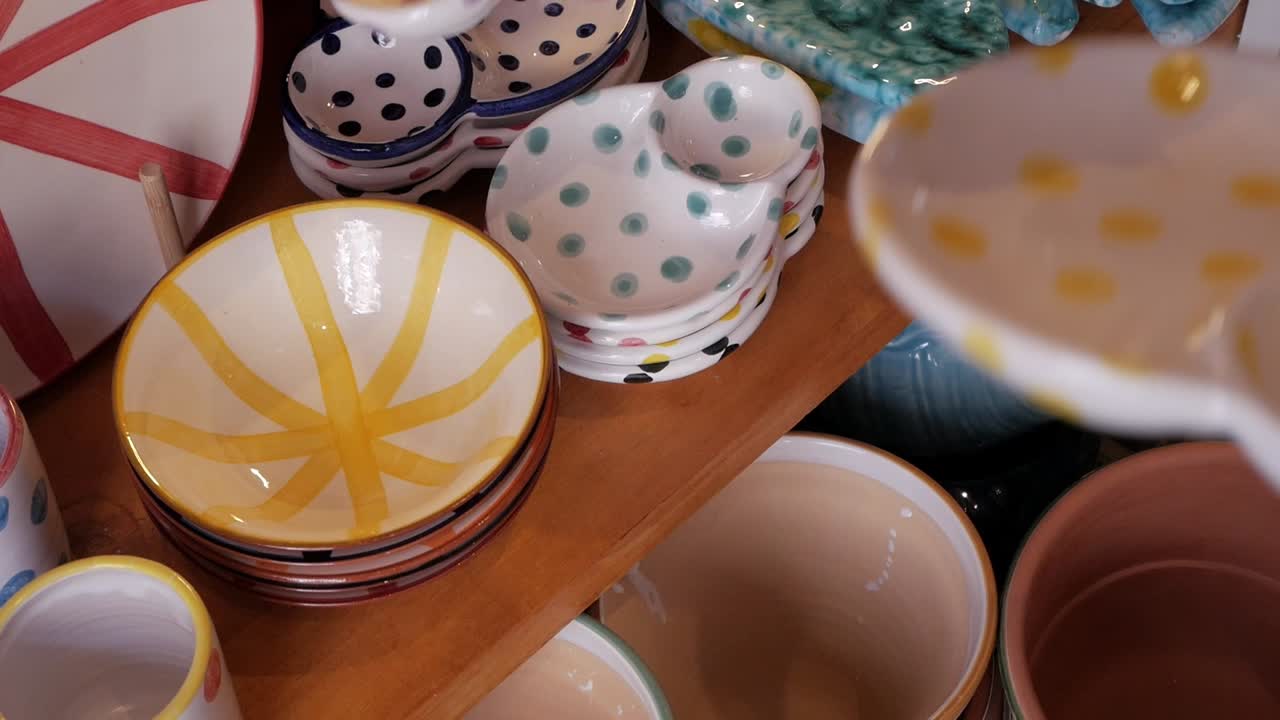 Colorful pottery bowls on display in a cozy shop, inviting and warm