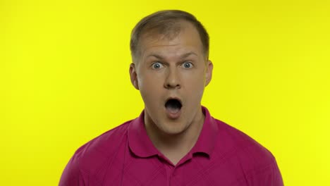 portrait of young caucasian man posing in pink t-shirt. amazed handsome guy shocked, surprised