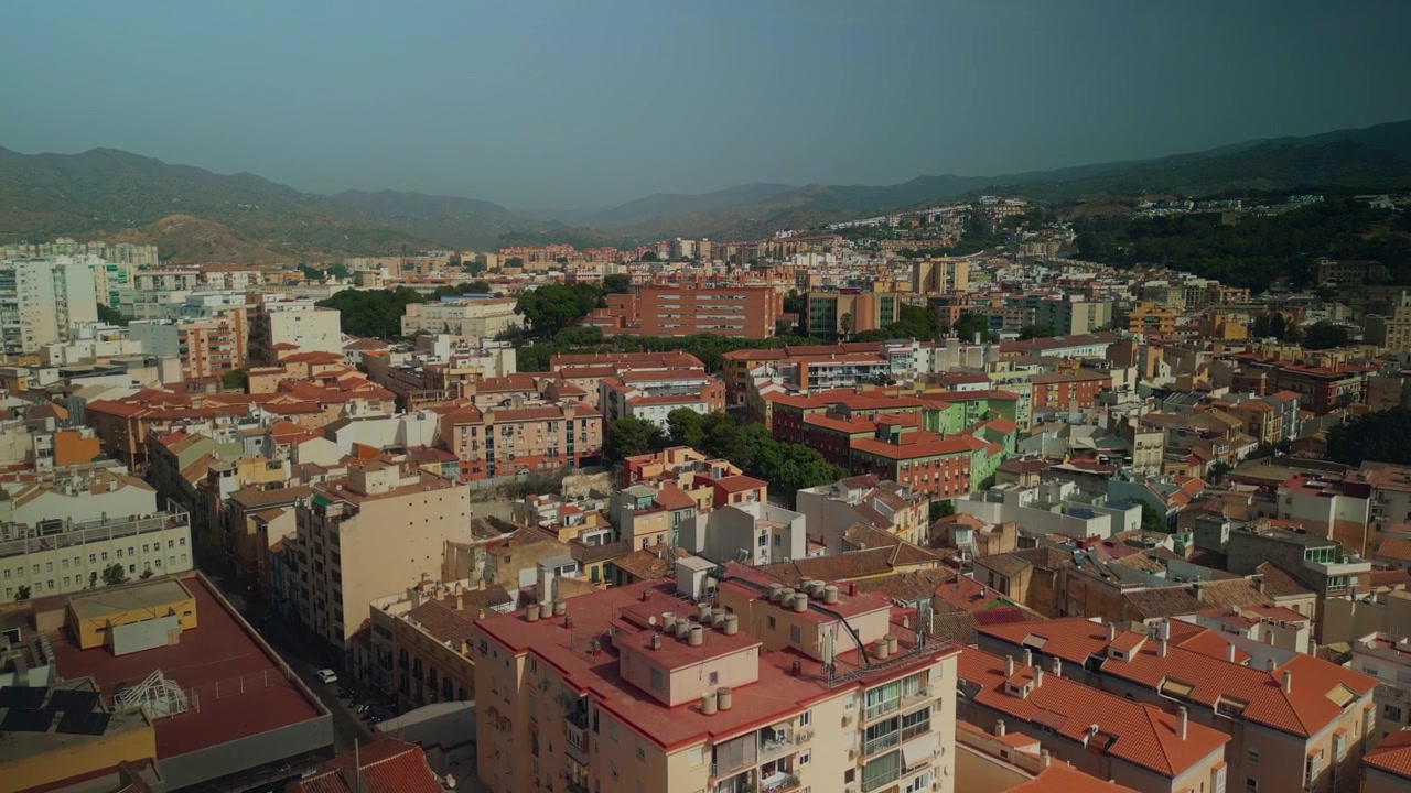 Vue aérienne d'une ville aux toits rouges et aux montagnes lointaines