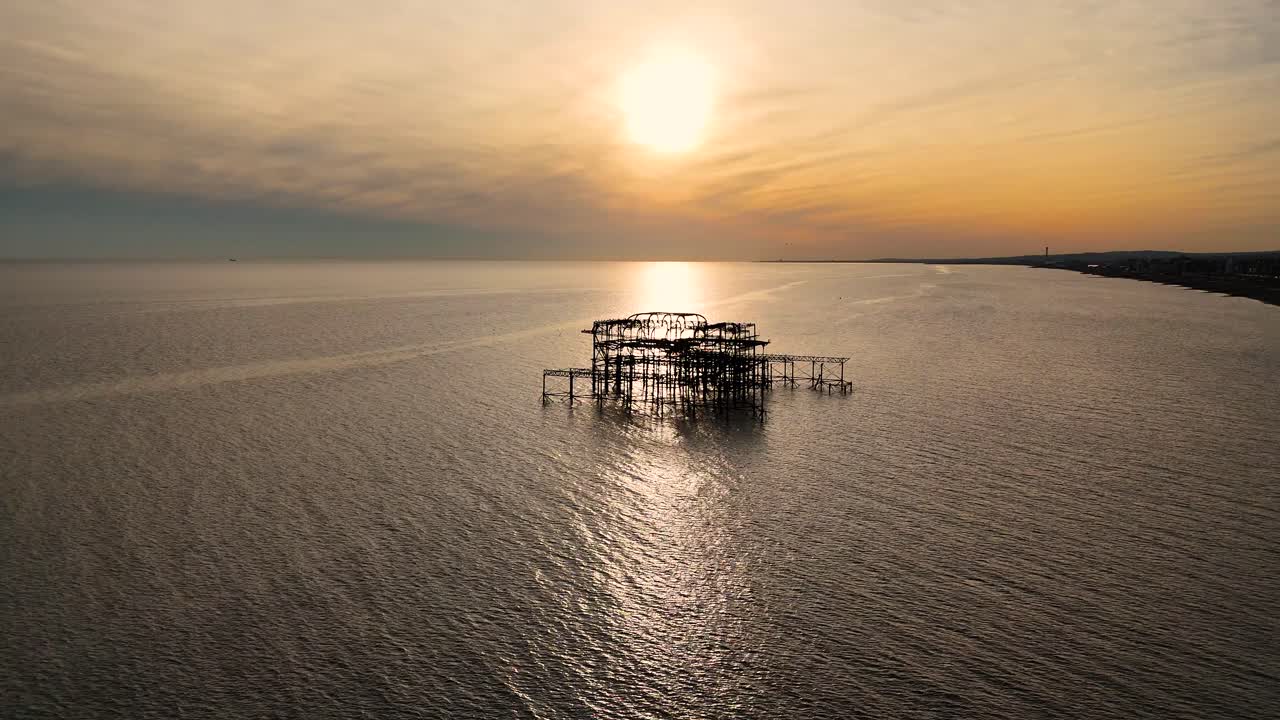 Breathtaking aerial footage of Brighton’s derelict West Pier at sunset. Golden hues reflect off the sea as the iconic ruins stand against the evening sky. Perfect for cinematic and coastal visuals.