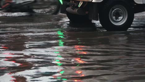 traffic in flooded streets with lights in the reflections