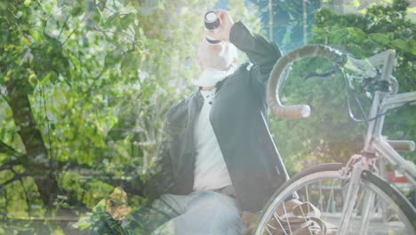 animation of leaves over caucasian man drinking takeaway coffee