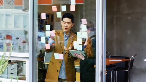 business executives discussing over sticky notes