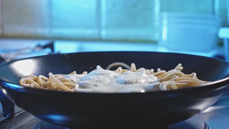 vista laterale frontale di spaghetti con salsa allo yogurt greco, cosparsi di sale, pepe e prezzemolo in cima