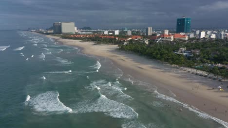 Drone-flying-over-My-Khe,-My-Bac-An-and-Non-Nuoc-white-sand-beach-with-huge-waves-in-Danang,-Central-Vietnam