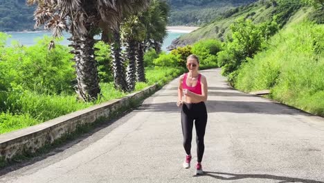 mujer corriendo en una carretera costera