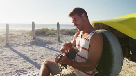 happy caucasian woman sitting beside beach buggy by the sea playing guitar