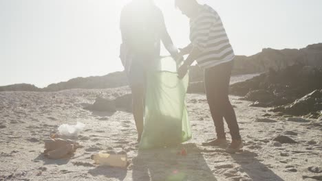 senior african american couple cleaning beach, slow motion