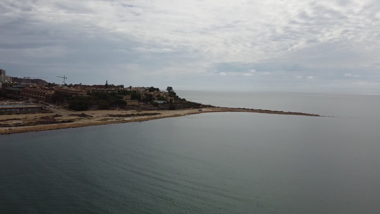 Sandy beach coastline Alicante Spain, gloomy cloudy day aerial, boats moored