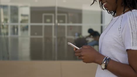 Side-view-of-female-hands-using-smartphone-on-blurred-background