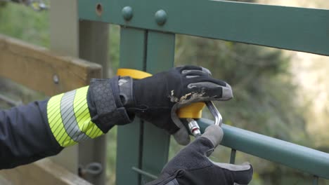 primer plano de las manos de los bomberos apretando la cuerda con mosquetón antes de descender