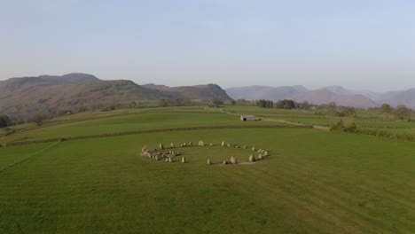 Vorbeifliegende-Drohnenaufnahme-Des-Steinkreises-Von-Castlerigg-Während-Der-Magischen-Stunde-Nach-Sonnenaufgang