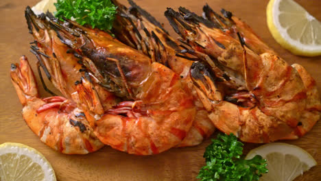 grilled tiger prawns or shrimps with lemon on wood board