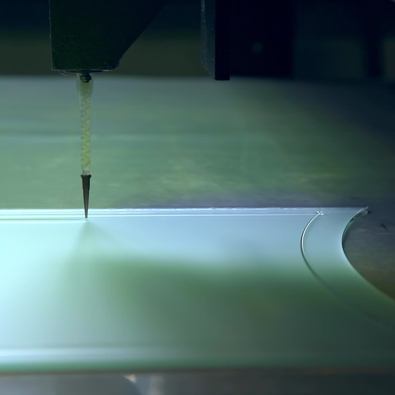 Making picture on the glass part of the door. Thin sharp instrument moves along drawing line. Close up