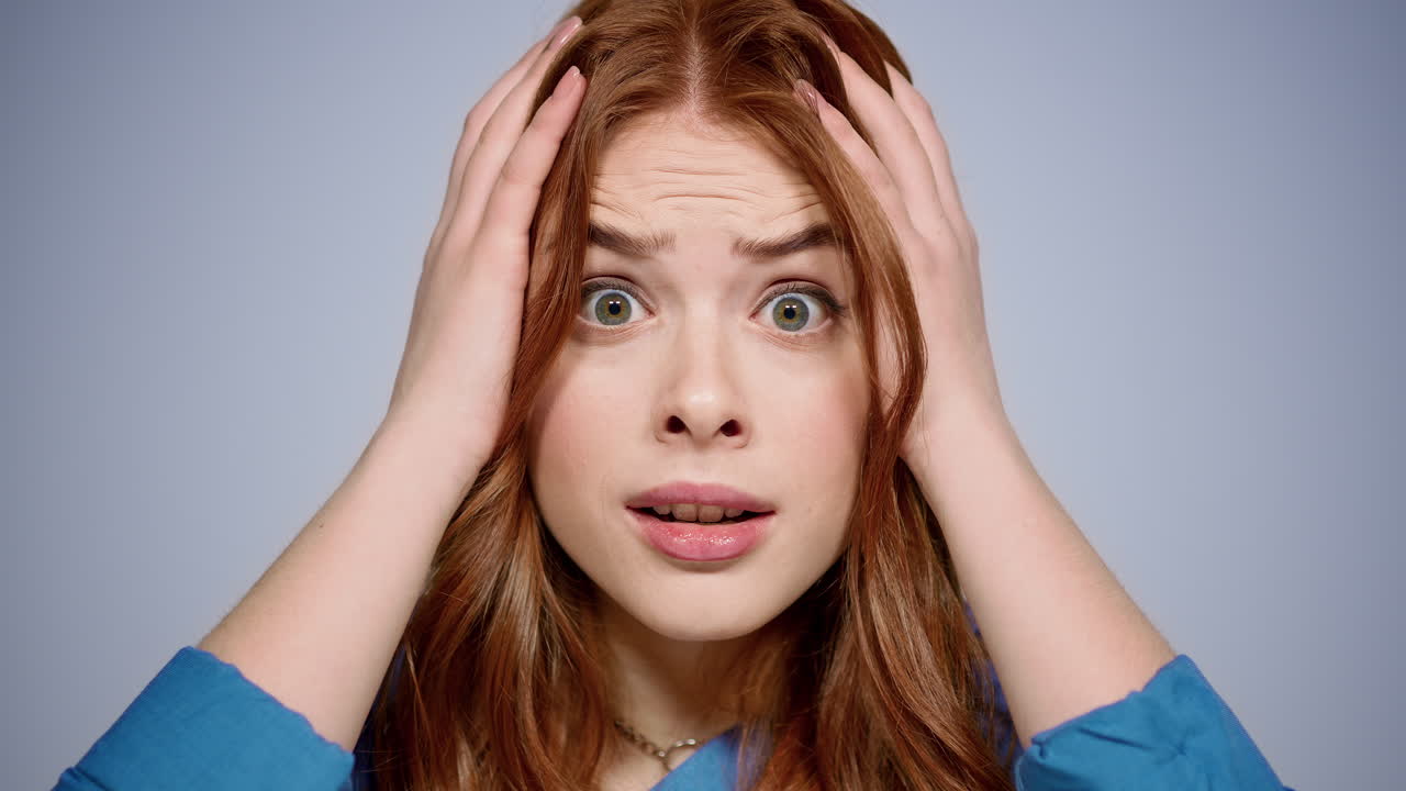 장미 여자가 실내에서 손을 들고 있다. 스트레스를 받은 소녀가 스튜디오에서 포즈를 취하고 있다.