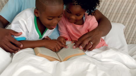 Padre-E-Hijos-Leyendo-En-La-Cama