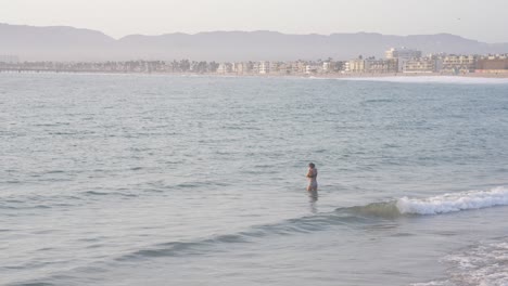 Joven-Madre-Sosteniendo-A-Su-Bebé-En-Las-Olas,-Cámara-Lenta