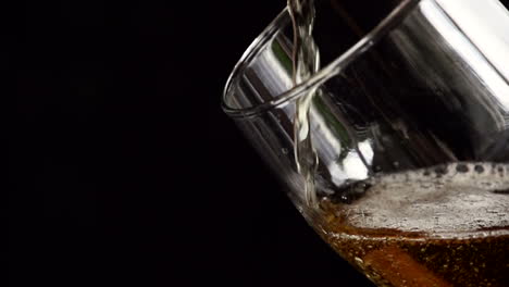liquid being poured into a glass, creating foam