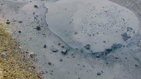 Active-bubbling-geothermal-formation-and-grey-hot-spring-geyser,-close-up-pan