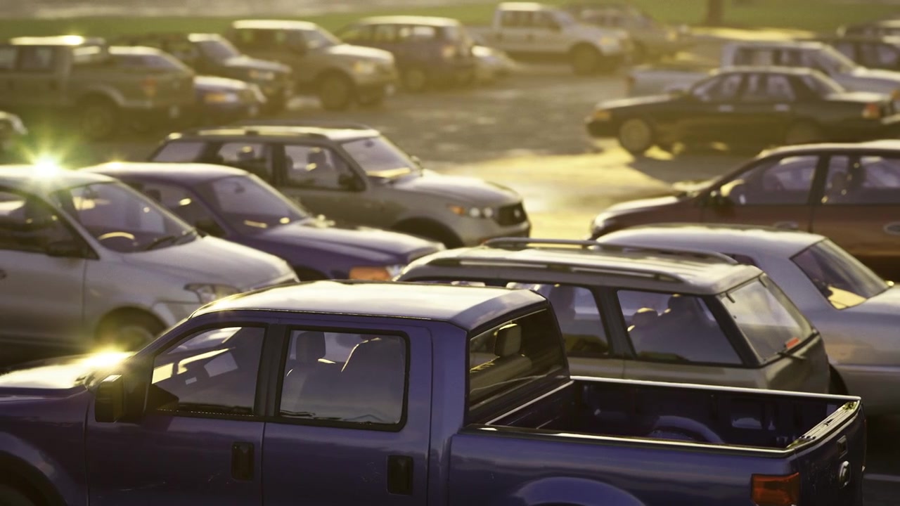 Numerous cars occupy tightly arranged parking spaces after sunset