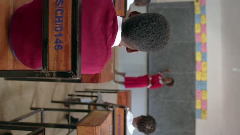 vertical shot of children in african classroom concentrating on teacher's discussion