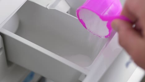 Close-up-slow-motion-shot-of-hands-pouring-laundry-household-washing-powder-detergent-laundry-stain-removal-washroom-clothing-fragrance-home-living-4K