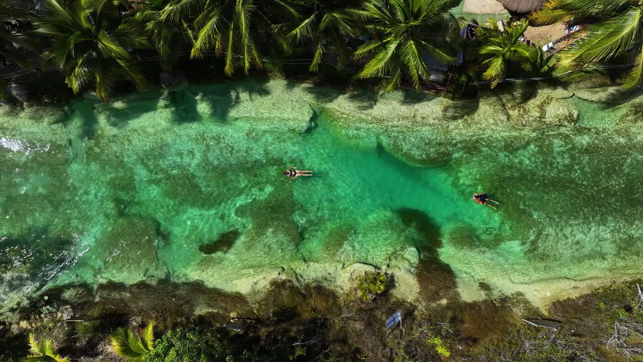 Luftfoto over mennesker, der flyder i Bacalar-strømfaldene, i solrige Mexico – zenitalt, droneoptagelse.