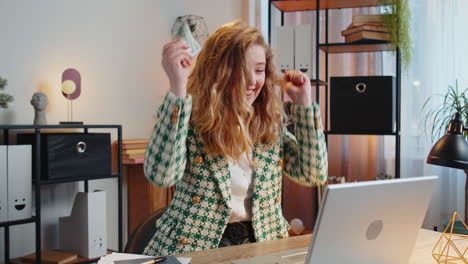 woman celebrates financial success by throwing money in the air.