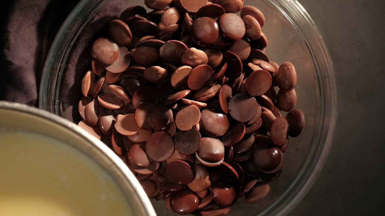 mantequilla a cámara lenta, crema, mezcla de leche vertida sobre gotas de chocolate