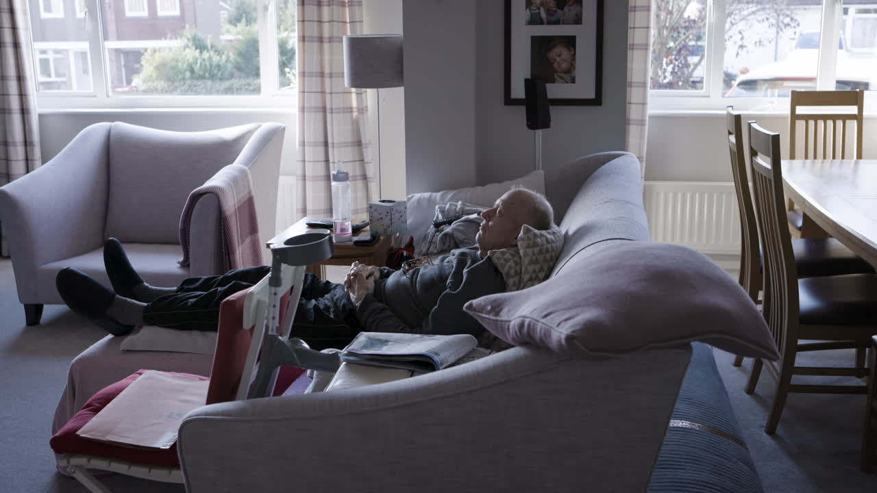 Elderly man relaxing on couch in living room