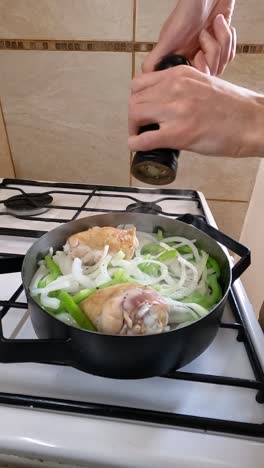 adding ground black pepper to chicken and vegetable preparation. vertical shot.