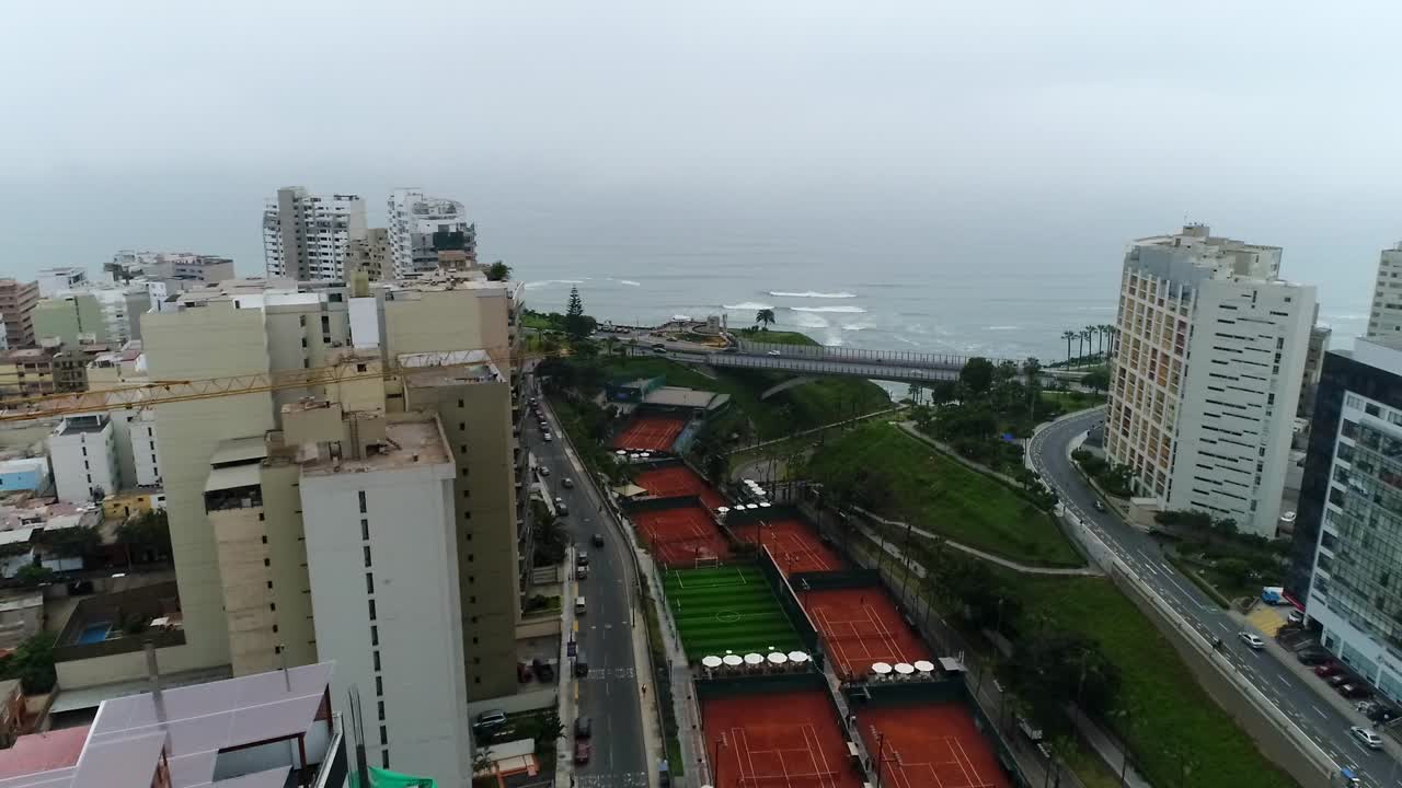 vista de drones sobre lima perú, edificios altos y el océano al fondo