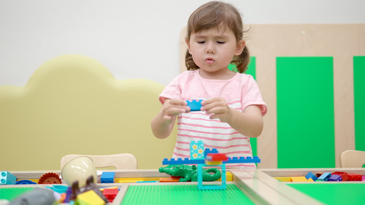 niña jugando con ladrillos de construcción coloridos en la sala de juegos