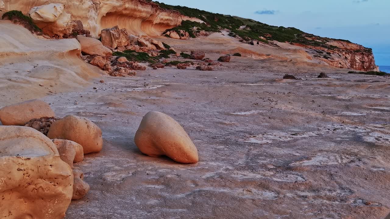 Sonnenuntergang über einem felsigen Strand an der Küste von Malta mit Klippen