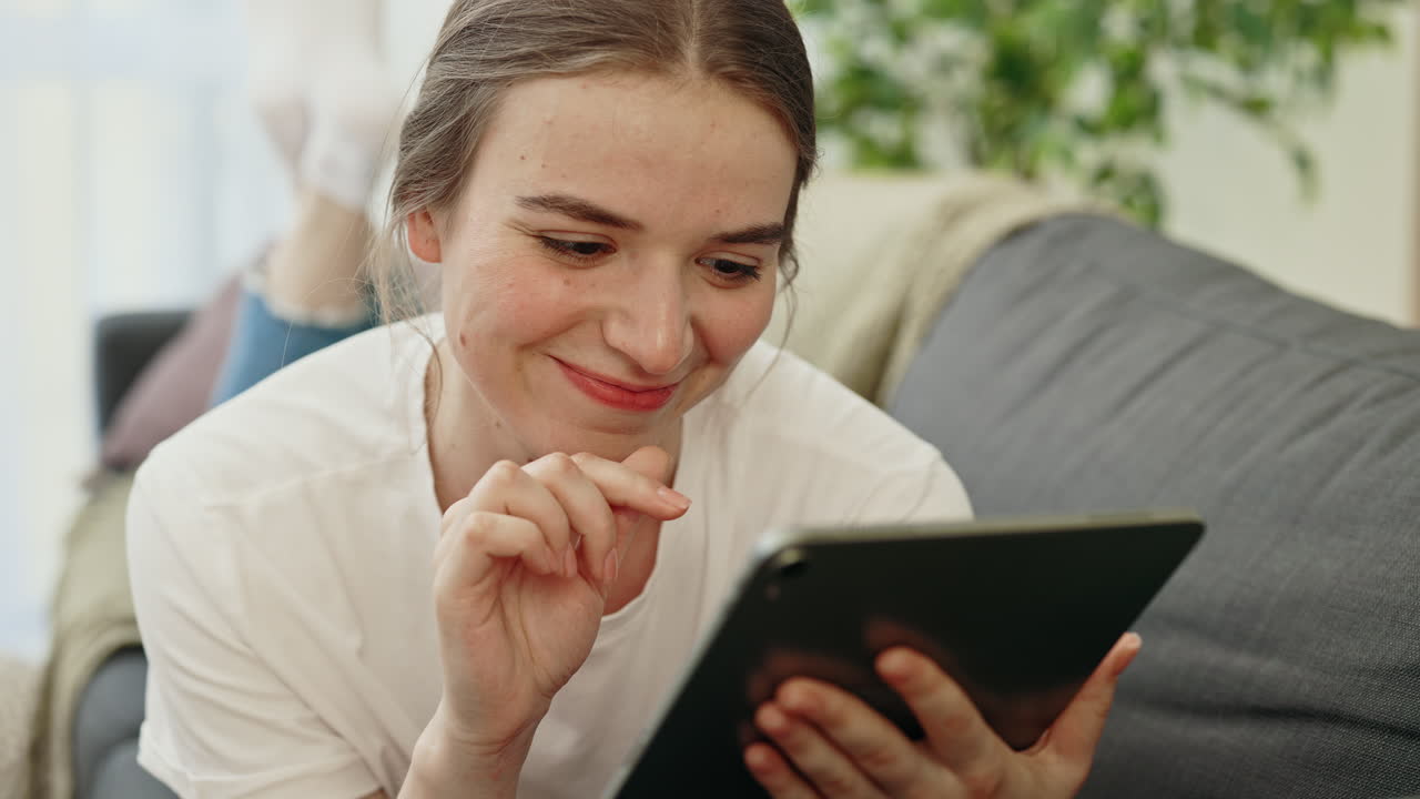Woman Relaxing on Couch Using Tablet