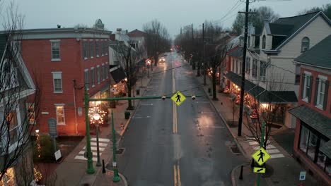 rising aerial reveals small town america, decorated with christmas lights