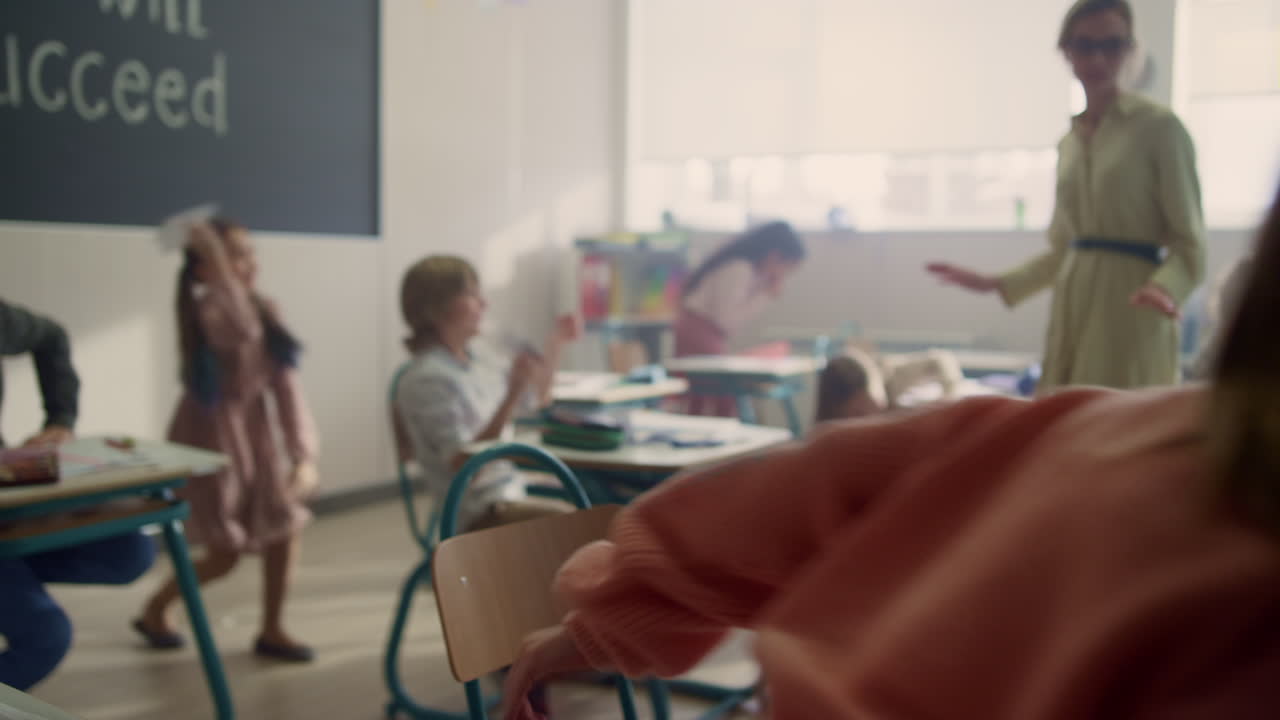 niños divirtiéndose en el aula. alumnos de raza mixta jugando con aviones de papel