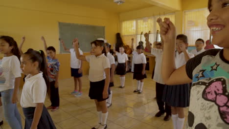 children in a classroom participating in a physical activity