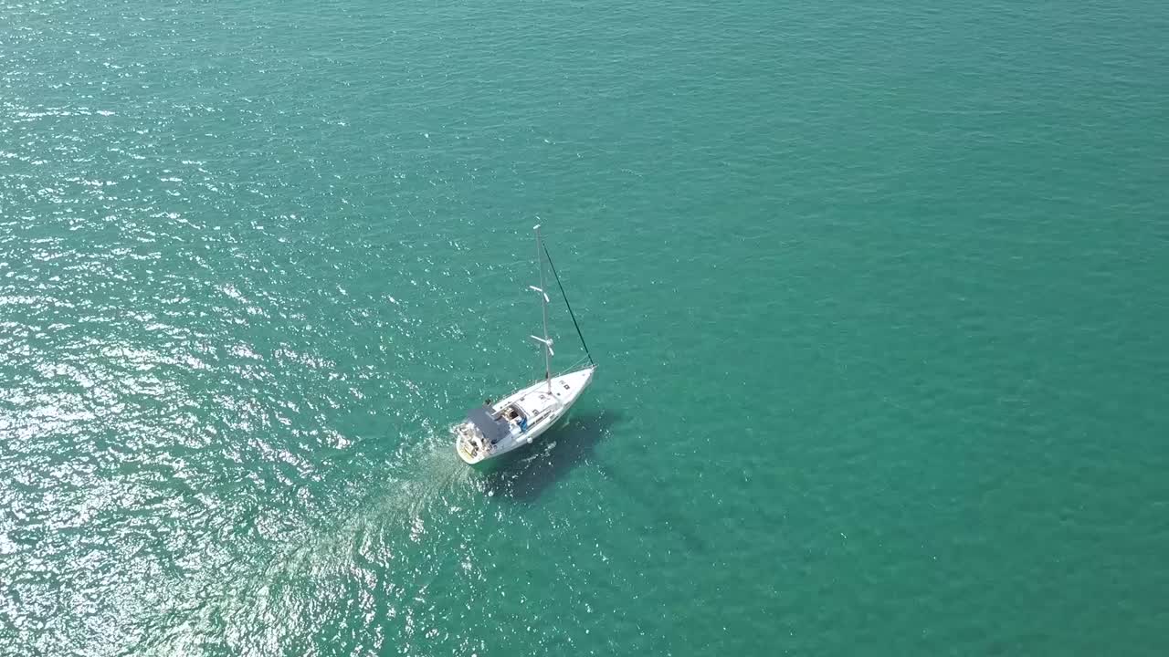 toma aérea de un pequeño bote navegando en el océano azul abierto hacia su destino, chipre