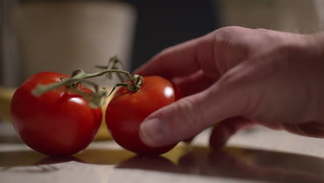 close up of two tomatoes on vine on a kitchen counter