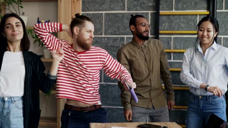 diverse group female and male start-up business team have fun dancing in modern office and celebrating success of project