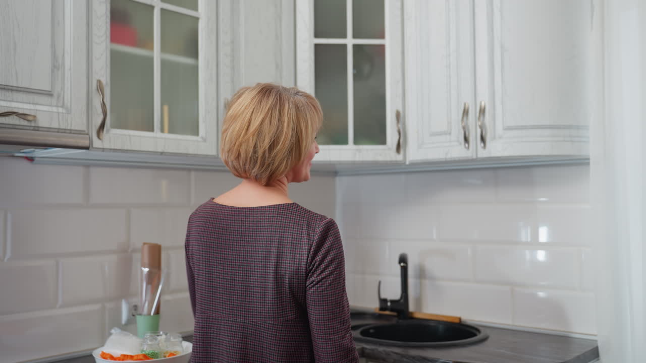 옷을 입은 사업가 여성은 책을 읽는 누군가의 부분적인 시야로 부으로 들어갑니다. 그녀는 부 캐비에 휴식을 취하면서 차분하고 평화로운 순간을 만들면서 따뜻하게 미소 짓습니다.