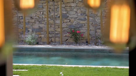 slow establishing shot of a private pool from the inside of a villa