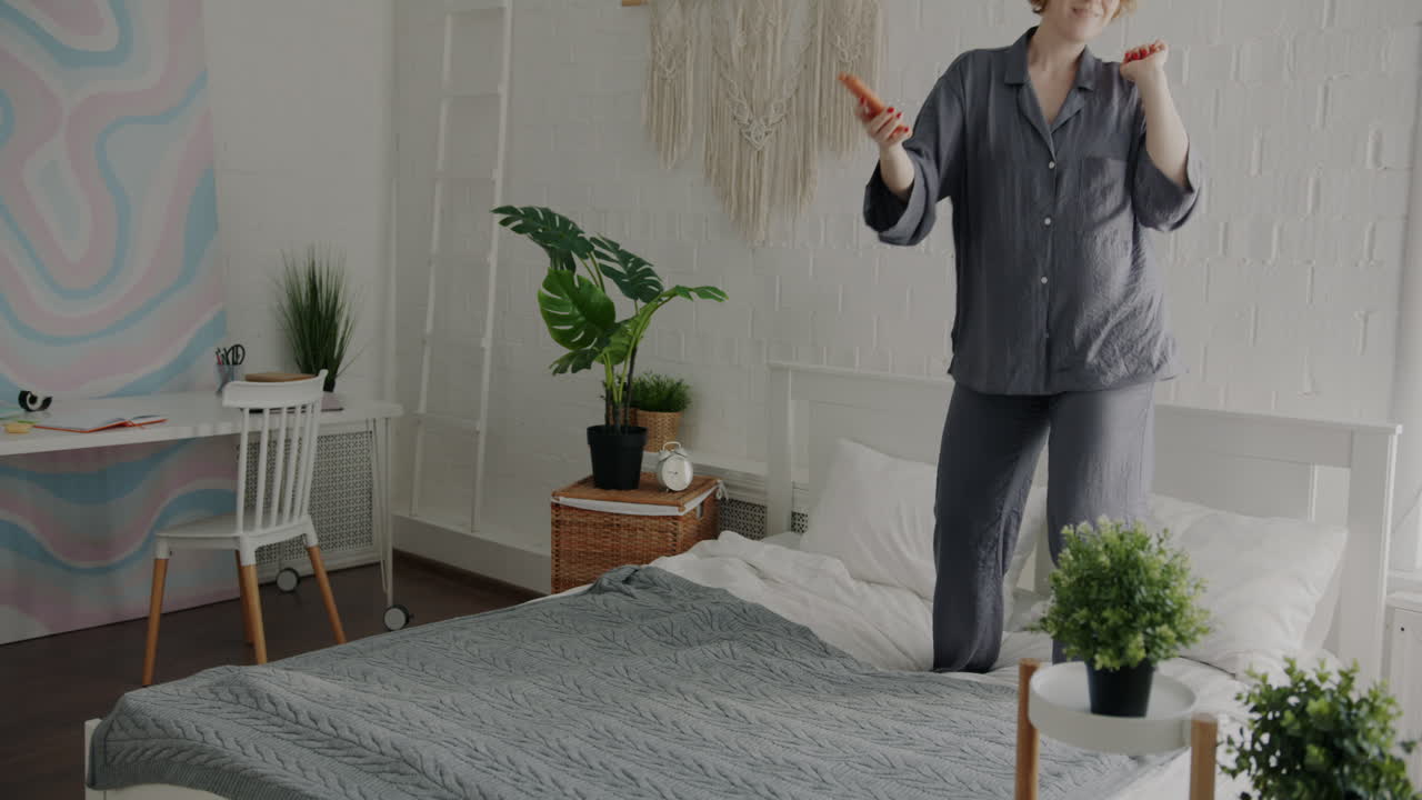 Woman Dancing in Pajamas on Bed