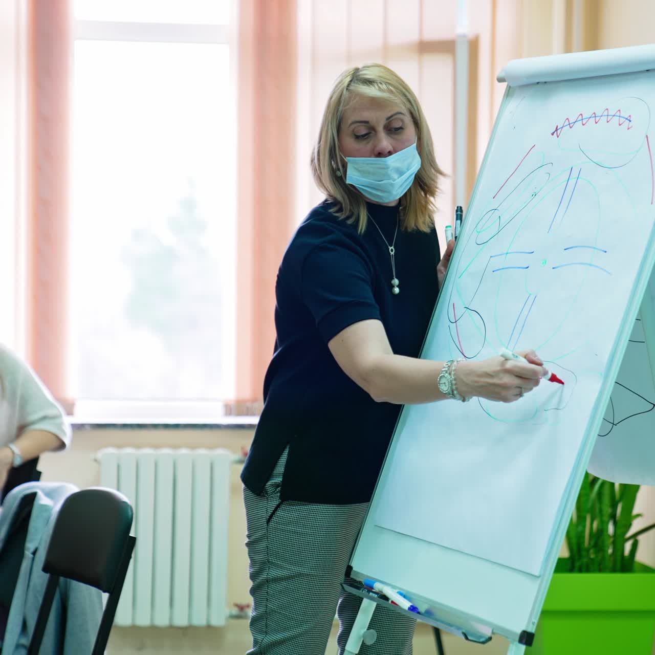 Lecturer reading a lecture on ophthalmology. Teacher drawing an eyeball scheme using diverse markers
