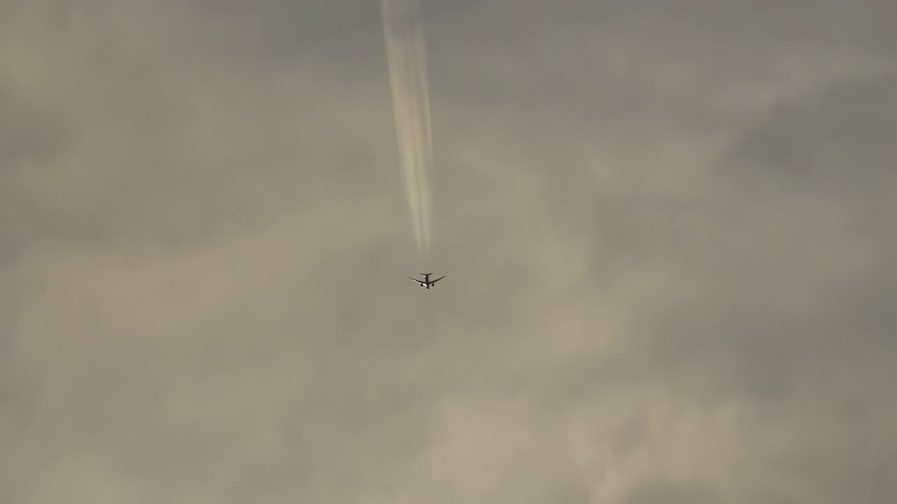 Kommersiellt flygplan flyger högt på himlen med kondensstrimmor