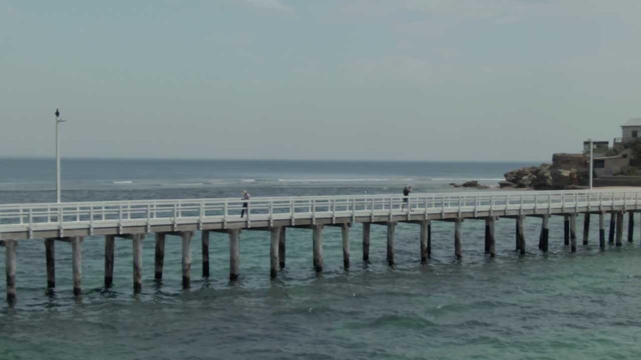 4k aerial pan-rise from pier to lighthouse