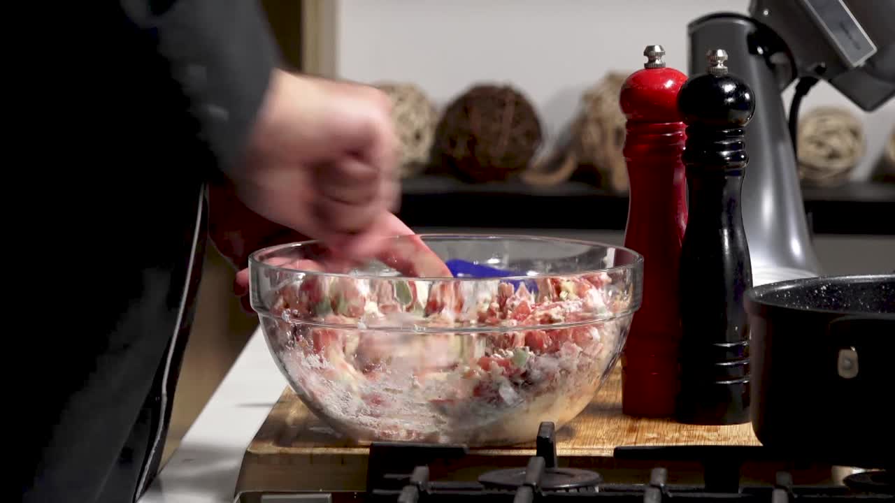 In this lively kitchen, a cook prepares a fresh salad by mixing chopped vegetables and flavorful herbs in a large bowl, creating a colorful and healthy dish