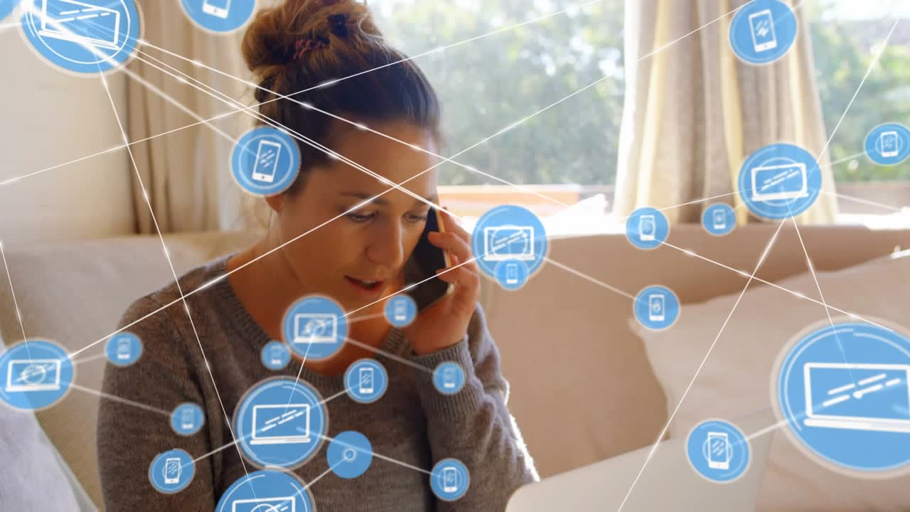 User is talking on the phone while using a laptop at home