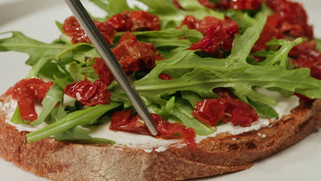 cream cheese toast with sun-dried tomatoes and arugula